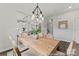 Bright dining area featuring a wooden table with seating for six, a modern light fixture and dark wood floors at 1198 Links Crossing Dr # 162P, Monroe, NC 28112