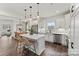 Bright, open kitchen showcasing stainless steel appliances, white cabinetry, an island with seating, and dark wood floors at 1198 Links Crossing Dr # 162P, Monroe, NC 28112