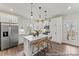Modern kitchen featuring white cabinets, stainless steel appliances, a center island with bar seating, and wood flooring at 1198 Links Crossing Dr # 162P, Monroe, NC 28112