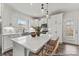 A modern kitchen with white cabinets, stainless steel appliances, a center island with bar seating and dark wood floors at 1198 Links Crossing Dr # 162P, Monroe, NC 28112