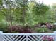 Serene backyard with lush greenery, colorful azaleas, and mature trees, creating a peaceful outdoor oasis at 121 General Pemberton St, Stanley, NC 28164