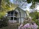 Charming backyard with a screened porch, a walkout basement, and lush landscaping at 121 General Pemberton St, Stanley, NC 28164
