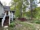 Well-maintained backyard featuring vibrant azaleas, mature trees, and an inviting deck for outdoor relaxation at 121 General Pemberton St, Stanley, NC 28164