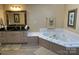 Bathroom featuring a tub with white tile details, a vanity with a dark countertop, and neutral walls at 121 General Pemberton St, Stanley, NC 28164