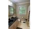 Bathroom featuring a black sink, toilet, and yellow-patterned shower curtain, all illuminated by natural light at 121 General Pemberton St, Stanley, NC 28164