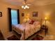 Cozy bedroom with floral bedding, lamps, and a ceiling fan, creating a comfortable and inviting atmosphere at 121 General Pemberton St, Stanley, NC 28164