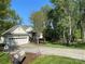 Charming home with a large front yard, mature trees, and long driveway to attached garage at 121 General Pemberton St, Stanley, NC 28164