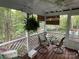Cozy porch showcasing stylish seating, a glass table, and scenic views of the surrounding lush landscaping at 121 General Pemberton St, Stanley, NC 28164