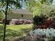 Charming side yard featuring colorful flowers in a natural setting at 121 General Pemberton St, Stanley, NC 28164
