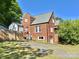 Backyard brick house featuring a driveway, partial fence, and a charming architectural structure at 121 W 11Th St, Oakboro, NC 28129