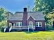 Charming brick home featuring a classic white-trimmed porch and a well-maintained front lawn at 121 W 11Th St, Oakboro, NC 28129