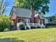 A charming red brick home with a white picket fence, beautiful lawn, and classic architectural details at 121 W 11Th St, Oakboro, NC 28129