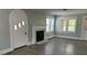 Bright living room with fireplace, hardwood flooring, an arched doorway, and large windows at 121 W 11Th St, Oakboro, NC 28129