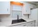 Close-up of a kitchen sink with modern fixtures, set against white cabinets and countertop, highlighting updated features at 1222 Glenarden Dr, Rock Hill, SC 29730