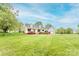 A charming white house featuring a welcoming front porch and attached two-car garage with beautiful landscaping at 123 Coachman Loop, Statesville, NC 28625