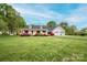 Charming single-story home with a lush front yard, vibrant landscaping, and an attached two-car garage at 123 Coachman Loop, Statesville, NC 28625