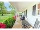 Relaxing front porch with ample seating overlooks a lush green lawn with colorful landscaping creating an inviting outdoor space at 123 Coachman Loop, Statesville, NC 28625