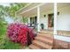Inviting front porch with brick stairs, seating, and vibrant landscaping creates a welcoming entrance to the home at 123 Coachman Loop, Statesville, NC 28625