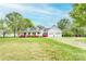 Charming white home featuring a welcoming front porch, two-car garage, and beautiful landscaping in a lush lawn at 123 Coachman Loop, Statesville, NC 28625