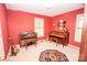 Red walled living room with piano, organ and guitar at 123 Coachman Loop, Statesville, NC 28625