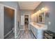 Bathroom with a double sink vanity, large mirrors, and an entrance to a walk-in closet for ample storage space at 12435 Mallard Dr, Charlotte, NC 28269