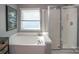 Bright bathroom with a soaking tub, a separate glass-enclosed shower, and a window providing plenty of natural light at 12435 Mallard Dr, Charlotte, NC 28269