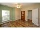Bright bedroom featuring hardwood floors, a ceiling fan, and a view to another room at 12435 Mallard Dr, Charlotte, NC 28269