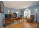 Bright home office with hardwood floors, comfortable seating, a large desk, and plenty of natural light from an arched window at 12435 Mallard Dr, Charlotte, NC 28269