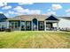 Exterior view of the home showcasing a spacious backyard and covered patio with comfortable seating at 12512 Journeys End Trl, Huntersville, NC 28078