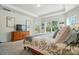 Comfortable bedroom with a wooden dresser, soft lighting, and large windows overlooking the yard at 12512 Journeys End Trl, Huntersville, NC 28078