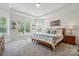 Bright bedroom with tray ceilings, large windows, a wooden bed frame, and neutral decor at 12512 Journeys End Trl, Huntersville, NC 28078