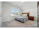 Bright bedroom featuring a wood bed frame, soft grey carpet, and a large window offering natural light at 12512 Journeys End Trl, Huntersville, NC 28078