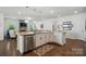Open kitchen with a large island, stainless steel dishwasher, and seamless flow into the living space at 12512 Journeys End Trl, Huntersville, NC 28078