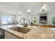 Well-appointed kitchen featuring a granite counter top island, pendant lighting, and open design to living space at 12512 Journeys End Trl, Huntersville, NC 28078