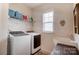Laundry room equipped with modern washer and dryer, utility sink, and storage shelf at 12512 Journeys End Trl, Huntersville, NC 28078