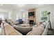 Inviting living room with a stone fireplace, large sectional sofa, and ample natural light at 12512 Journeys End Trl, Huntersville, NC 28078