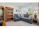Bright and cozy living room with large windows, blue sofa, recliner, and wooden shelving at 12512 Journeys End Trl, Huntersville, NC 28078