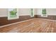 Bright bedroom featuring hardwood floors, natural light, and three windows at 1280 Willowbreeze Sw Ct, Concord, NC 28025