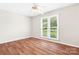 Secondary bedroom with hardwood floors, ceiling fan, and a large window at 1280 Willowbreeze Sw Ct, Concord, NC 28025