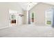 A neutral bedroom has large windows, vaulted ceilings, and attached bathroom at 1280 Willowbreeze Sw Ct, Concord, NC 28025