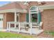 Cozy front porch featuring a white railing, wooden bench, chairs, and tasteful decor at 1280 Willowbreeze Sw Ct, Concord, NC 28025