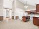 Open kitchen with an island, white appliances, and wooden cabinets at 1280 Willowbreeze Sw Ct, Concord, NC 28025