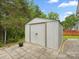 Outdoor storage shed with double doors and concrete paver foundation at 1280 Willowbreeze Sw Ct, Concord, NC 28025