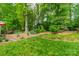 Lush backyard features a beautiful garden, mature trees, and expansive green lawn at 14926 Chilgrove Ln, Huntersville, NC 28078