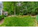 Well-maintained backyard with mature trees, garden, and a view of the home's exterior at 14926 Chilgrove Ln, Huntersville, NC 28078
