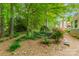 Charming backyard sitting area with garden, lush trees, and decorative gravel pathway at 14926 Chilgrove Ln, Huntersville, NC 28078