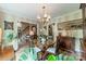 Well-lit dining room showcases hardwood floors, a chandelier, and a connecting view to staircase at 14926 Chilgrove Ln, Huntersville, NC 28078