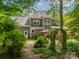 Exterior home view with mature trees, patio chairs, and a well-manicured lawn at 14926 Chilgrove Ln, Huntersville, NC 28078