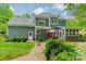 Exterior home view featuring well-maintained yard, covered patio, and ample natural light at 14926 Chilgrove Ln, Huntersville, NC 28078