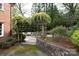 An inviting back patio is showcased with blooming pergola, stone accents, and outdoor seating at 1943 S Wendover Rd, Charlotte, NC 28211